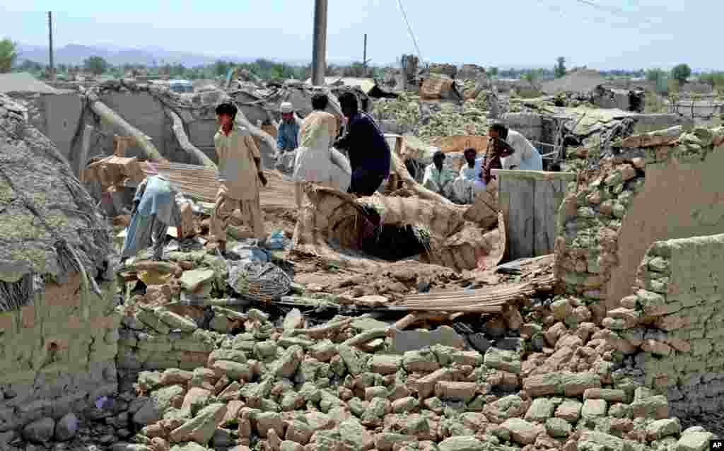 Warga desa mencari barang-barang milik mereka di antara reruntuhan rumah mereka akibat gempa di daerah terpencil Awaran, provinsi Baluchistan, Pakistan (25/9). (AP/Arshad Butt)