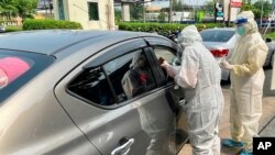 Medical workers conduct swab tests on passengers at a drive-thru COVID-19 testing site outside a hospital in Nonthaburi, Thailand, April 10, 2021.