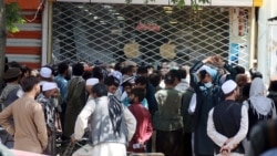 Afghans wait for hours to try to withdraw money, in front of Kabul Bank, in Kabul, Afghanistan, Saturday, Aug. 28, 2021. (AP Photo/Khwaja Tawfiq Sediqi)