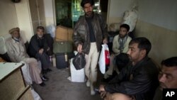 Gilgit-bound passengers wait for a bus as transporters suspend their service due to firing on their buses, at a bus terminal in Islamabad, Pakistan, February 28, 2012.