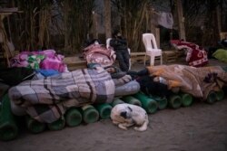 People sleep on top of empty oxygen cylinders, waiting for a shop to open to refill their tanks, in the Villa El Salvador neighborhood, as the lack of medical oxygen to treat COVID-19 patients continues in Lima, Peru, April 6, 2021.