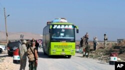 Pasukan Suriah mengawasi evakuasi warga dari dua desa pro-pemerintah Foua dan Kfarya dengan bus, di Tel el-Eis, persimpangan antara provinsi Aleppo dan Idlib,Suriah, 19 Juli 2018. (Foto: dok).