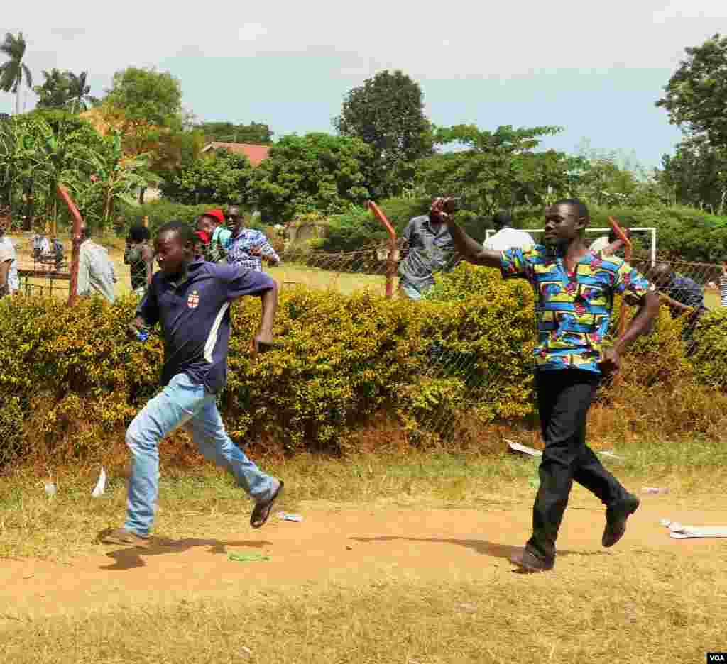 Voters run from tear gas fired at them by police (E. Paulat/VOA)