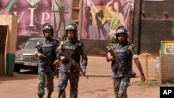 FILE - In this file photo taken on Saturday, March 7, 2015, armed forces provide security for the nightclub, seen rear, that was attacked by gunmen in Bamako, Mali. Mali Violence