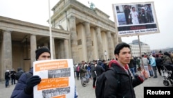 Warga memprotes deportasi pengungsi Afghanistan dari Jerman di Brandenburg Gate di Berlin (11/2).(Reuters/Fabrizio Bensch)