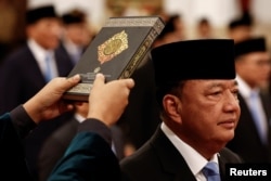 FILE - Pengambilan sumpah jabatan Menteri Koordinator Bidang Politik dan Keamanan yang baru dilantik Budi Gunawan, mantan kepala Badan Intelijen Negara, bersama menteri lainnya, saat pelantikan di Istana Kepresidenan di Jakarta, 21 Oktober 2024. (Willy Kurniawan/REUTERS)