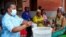 FILE - Violett Motta, a health surveillance assistant in Malawi, mixes chlorine with water to disinfect it at a health center in response to the latest cholera outbreak in Blantyre, Malawi, Nov. 16, 2022. 