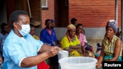 FILE - Violett Motta, a health surveillance assistant in Malawi, prepares disinfectant at a health center in response to a cholera outbreak in Blantyre, Nov. 16, 2022. The country on July 15, 2024, declared that its deadliest cholera outbreak was over.