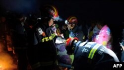 This photo taken on May 22, 2021 shows rescuers assisting people who were competing in a 100-kilometre cross-country mountain race when extreme weather hit the area, leaving at least 20 dead, near the city of Baiyin in China's northwestern Gansu.