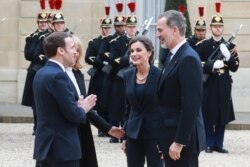 FILE - France's President Emmanuel Macron (L), with his wife Brigitte Macron, welcomes King Felipe VI (R) and Queen Letizia of Spain (2nd R) with what appears to be a "namaste" greeting, at the Elysee Palace in Paris, France, March 11, 2020.