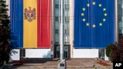 FILE - A government building is decorated with European Union and Moldovan flags in Chisinau, Moldova, on May 31, 2023. Officials said on June 4, 2024, that Interpol and the FBI, along with the governments of Moldova, France and Britain, disrupted a criminal scheme in Moldova.
