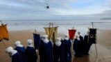 People role playing as members of the royal entourage await the arrival of the Three Wise Men by helicopter, at San Lorenzo beach in Gijon.&nbsp;Children in Spain traditionally receive their Christmas presents on the morning of Jan. 6, delivered by the Three Wise Men.