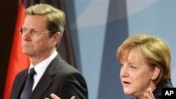 ນາຍົກລັດຖະມົນຕີ Angela Merkel ແຫ່ງເຢຍຣະມັນ ຢືນຢູ່ຂ້າງຂວາ
ຮອງນາຍົກ Guido Westerwelle ວັນທີ 12 ມີນາ 2011
