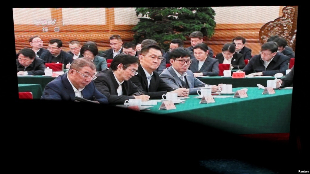 北京某购物中心的巨型电子屏幕播放的新闻画面显示，数位知名中国民营企业家在北京举行的一个座谈会上听取中国领导人习近平讲话的场景。（2025年2月17日）