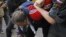 Russian police detain an opposition activist, with the white ribbon as a symbol of protest, during an anti-Kremlin protest in Moscow, May 31, 2012.