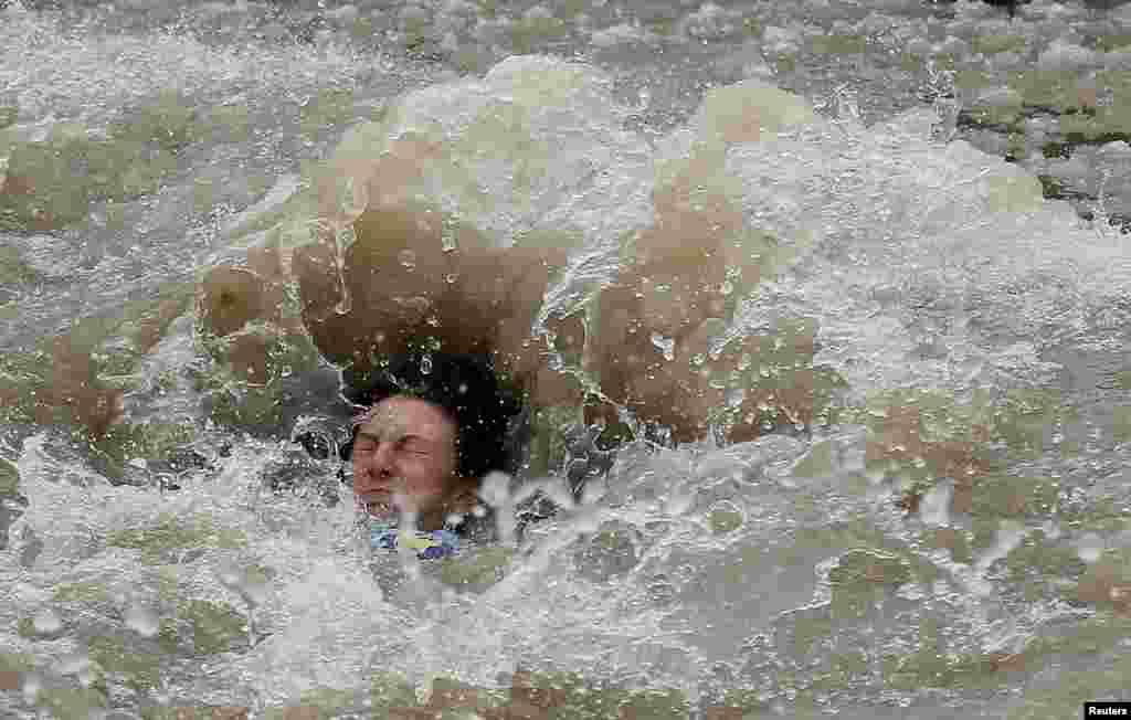 A participant in the Chicago Polar Plunge is engulfed by the partially frozen waters of Lake Michigan in Chicago, Illinois, March 1, 2015.