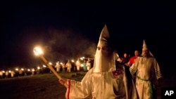 Anggota Ku Klux Klan berpartisipasi dalam pembakaran silang setelah reli "kebanggaan putih" di daerah pedesaan Paulding dekat Kota Cedar, 23 April 2016. (Foto: AP)