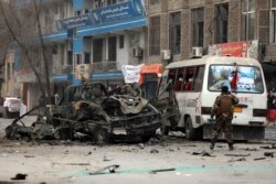 FILE - Afghan security personnel inspect the site of a bomb attack in Kabul, Afghanistan, Dec. 26, 2020.