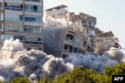 Sebuah bangunan runtuh setelah serangan udara Israel di kawasan Ghobeiry, selatan Beirut, pada 15 November 2024, di tengah perang yang sedang berlangsung antara Israel dan Hizbullah. (Foto: AFP)