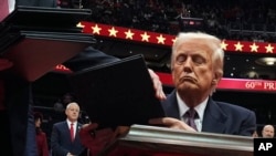 El presidente Donald Trump firma órdenes ejecutivas mientras asiste a un evento por su investidura en el Capital One Arena, el lunes 20 de enero de 2025, en Washington.