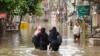 People wade through floodwaters after heavy monsoon rains in Multan, Pakistan, Aug. 30, 2024. 