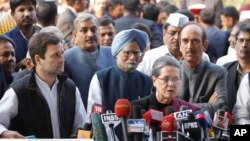 India's Congress Party President Sonia Gandhi, front, and her son and party Vice President Rahul Gandhi, left, addresses the media about her corruption accusation in New Delhi, India, Dec. 19, 2015. The Gandhis deny the allegations.