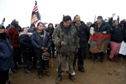 FILE - Protesters pray during a rally against the Dakota Access oil pipeline, near Cannon Ball, North Dakota, Feb. 22, 2017.
