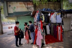 FILE - People shop for clothes at the Janpath market in New Delhi, India, June 1, 2020, amid the coronavirus pandemic.