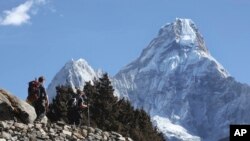 FILE - Trekkers make their way to Dingboche, a popular Mount Everest base camp, in Pangboche, Nepal, Feb. 19, 2016.