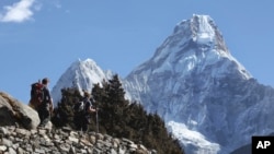 FILE - Trekkers make their way to Dingboche, a popular Mount Everest base camp, in Pangboche, Nepal, Feb. 19, 2016.