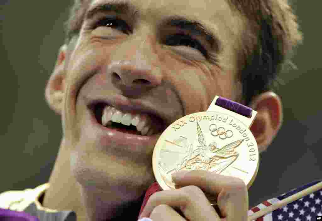 United States' Michael Phelps poses with his gold medal for the men's 4x200-meter freestyle relay swimming final at the Aquatics Centre in the Olympic Park during the 2012 Summer Olympics in London, July 31, 2012.