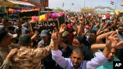 Mourners carry the coffins of two people, killed in protests at Baghdad's International Zone on Friday, during their funeral procession at the holy shrine of Imam Ali, in Najaf, 160 kilometers south of Baghdad, Iraq, May 21, 2016. 