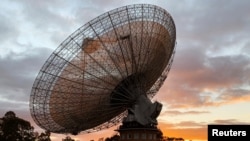 FILE - A radio telescope at the Parkes Observatory is pictured at sunset near the town of Parkes, Australia, July 15, 2019. The new Square Kilometre Array project will combine 130,000 antennas and 200 satellite dishes.