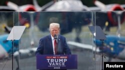 Calon presiden dari Partai Republik dan mantan Presiden AS Donald Trump berbicara dari balik kaca antipeluru sdi North Carolina, AS, 21 Agustus 2024. (Foto: Reuters)