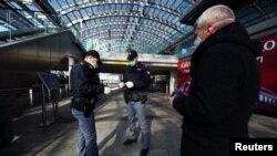 이탈리아 정부가 신종 코로나바이러스 감염 확산을 막기 위해 전국적인 이동 제한령을 내린 가운데, 10일 토리노포르타 기차역에서 경찰관이 승객의 서류를 확인하고 있다.