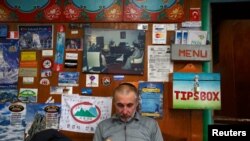 FILE - American climber Alex Goldfarb, who had to cancel his planned climb of Mount Lhotse, reads a book in Solukhumbu District May 5, 2014.