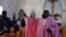 The Rev. Athanasius Abanulo waves to his parishioners after Mass, at Immaculate Conception Catholic Church in Wedowee, Ala., Dec. 12, 2021.