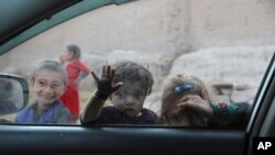 Children look into a window of a car on the outskirts of Jalalabad city east of Kabul, Afghanistan.