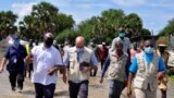 Alain Noudehou, UN Humanitarian Coordinator in South Sudan, and Matthew HollingWorth, the Country Director of World Food Program (WFP), wade through flood water in Duk padiet county of Jonglei State, in South Sudan, Sept. 24, 2020.