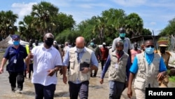 Alain Noudehou, UN Humanitarian Coordinator in South Sudan, and Matthew HollingWorth, the Country Director of World Food Program (WFP), wade through flood water in Duk padiet county of Jonglei State, in South Sudan, Sept. 24, 2020.