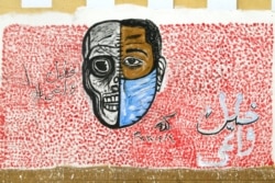 FILE - Graffiti depicting the importance of face masks, part of a COVID-19 awareness-raising campaign, are pictured with the Arabic hashtag "Stay aware" on a wall in the Sudanese capital, Khartoum, on April 8, 2020.