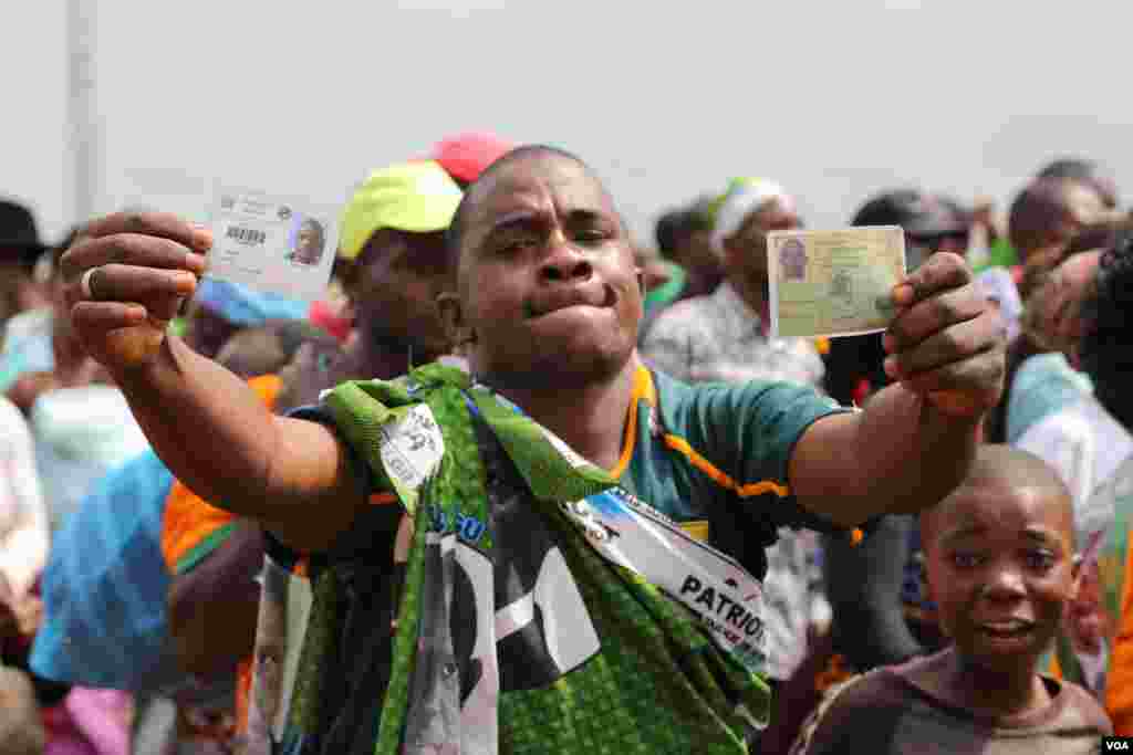 A Patriotic Front supporter proudly displays his identification and voter cards, Lusaka, Zambia, Jan. 20, 2015. (Gillian Parker/VOA)