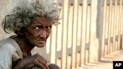 A homeless Indian woman begs on a bridge in Mumbai (file photo)