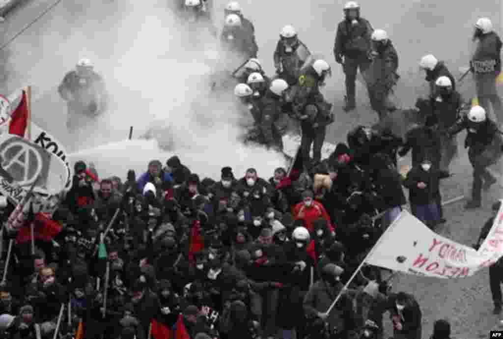 Riot police clash with protesters outside the Greek Parliament during a demonstration in central Athens, Wednesday, Dec. 15, 2010. Hundreds of protesters clashed with riot police across central Athens Wednesday, smashing cars and hurling gasoline bombs du