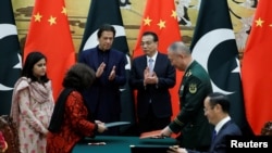 FILE - Pakistan's Prime Minister Imran Khan and Chinese Premier Li Keqiang attend a signing ceremony at the Great Hall of the People in Beijing, China, Oct. 8, 2019. 