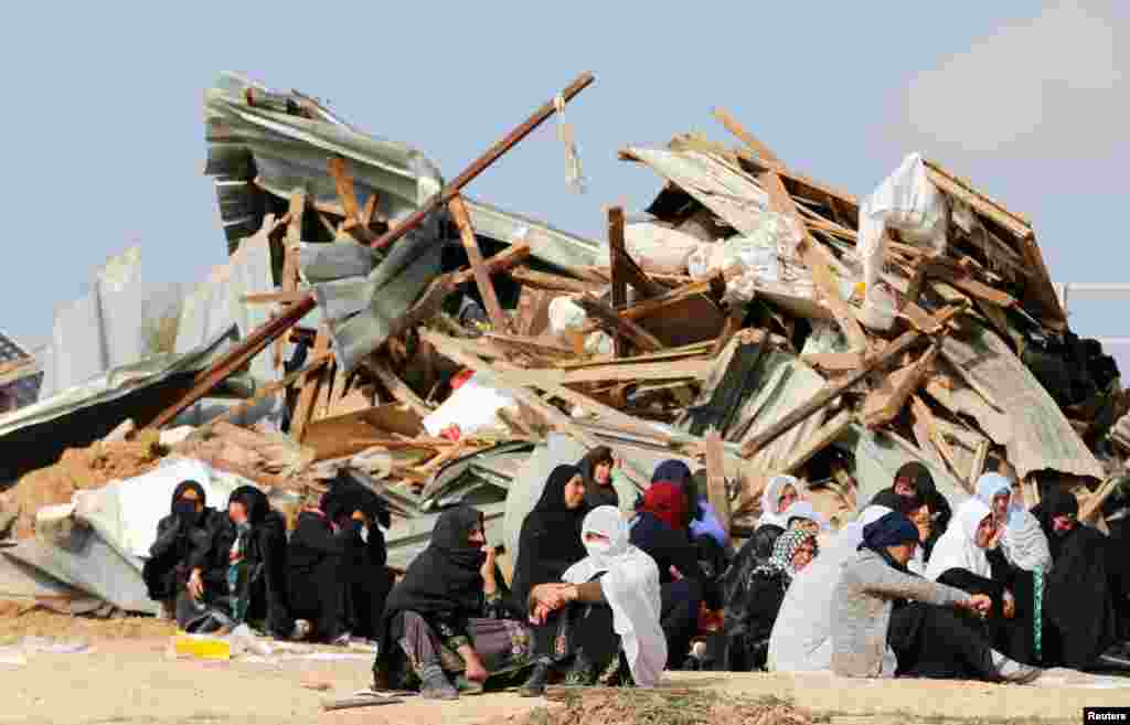 Arab Israeli women sit next to the ruins of their dwellings which were demolished by Israeli bulldozers in Umm Al-Hiran, a Bedouin village in Israel&#39;s southern Negev Desert.