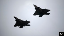 FILE - Two U.S. Air Force F-22 fighter jets perform a flyover during the playing of the national anthem before a NASCAR Cup Series auto race at Daytona International Speedway, July 7, 2018, in Daytona Beach, Florida.