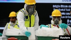 FILE - Police officers destroy seized cocaine under judicial supervision in Katunayake, Sri Lanka, Jan. 15, 2018. 