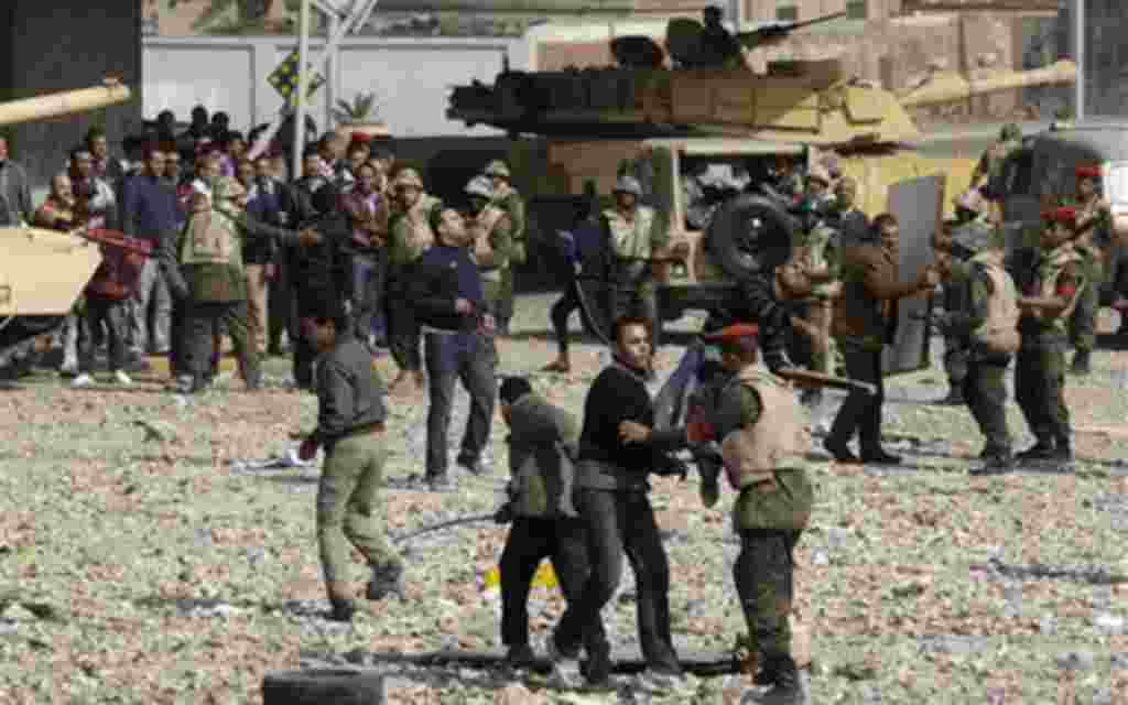 Pro-government supporters are restrained by soldiers just outside Cairo's main square, Egypt, Thursday, Feb. 3, 2011. Egypt's prime minister apologized for the attack by regime supporters on anti-government protesters in central Cairo, vowing to investiga