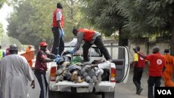 Petugas mengangkut jenazah para korban tewas dalam ledakan bom di kota Kano, Nigeria utara (21/1).